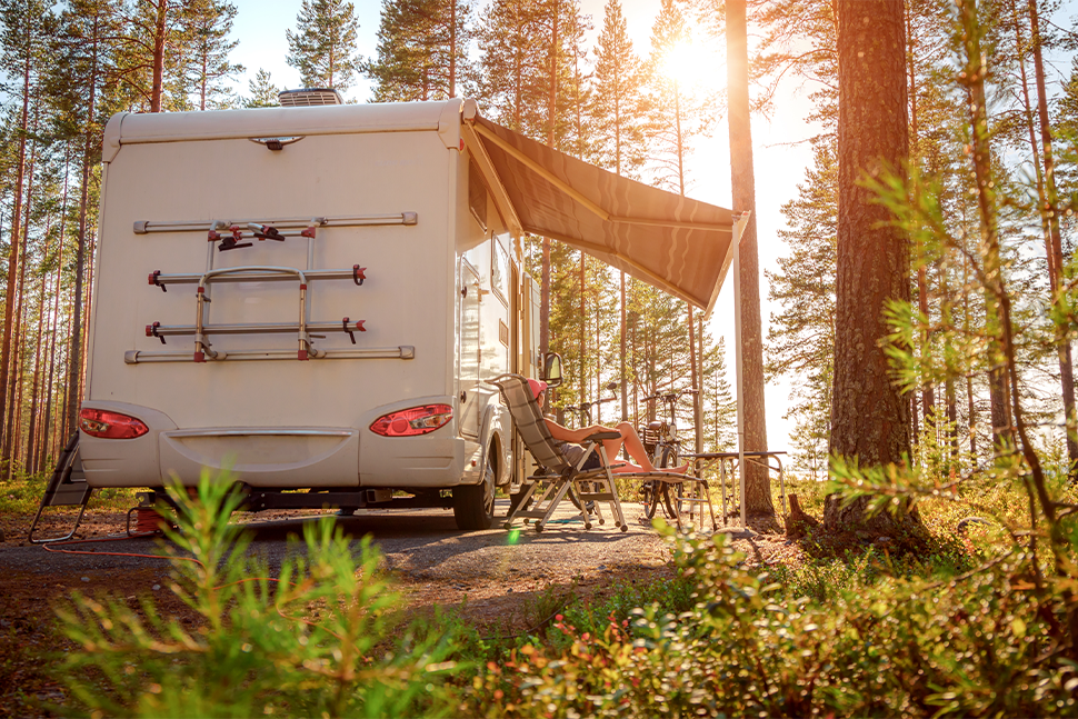 woman sitting outside her motorhome enjoying the sunset